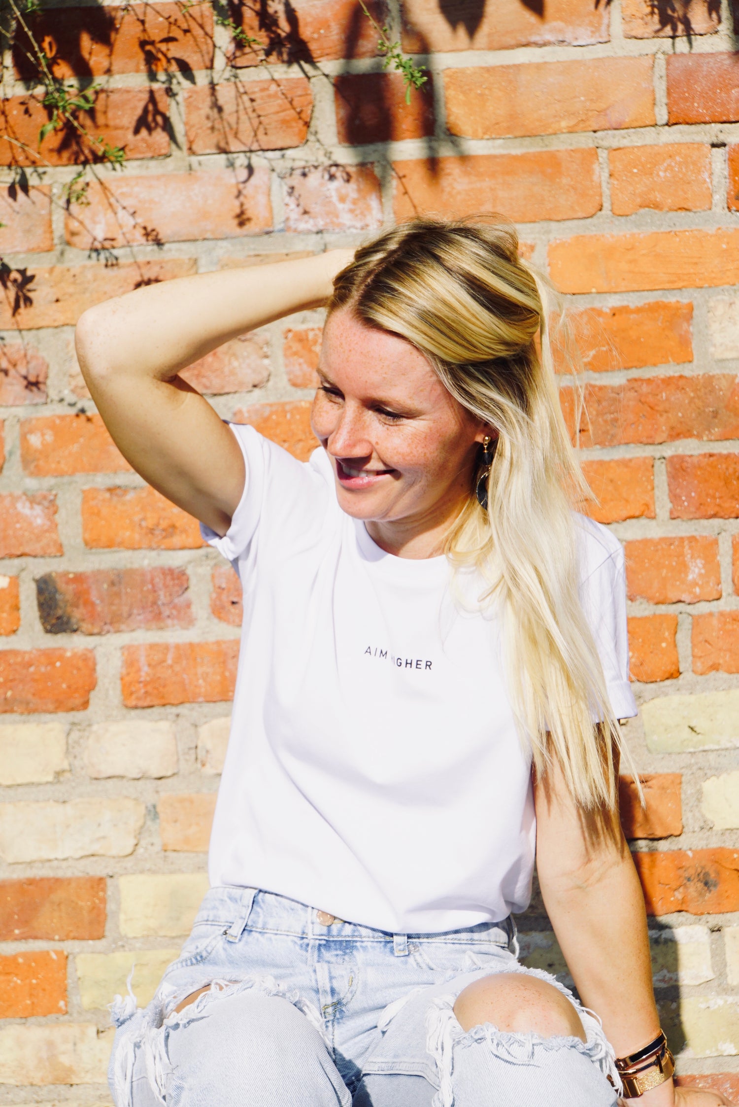 Unisex T-Shirt in der Farbe Weiß mit dem Print "AIM HIGHER". Super lässige Streetwear.