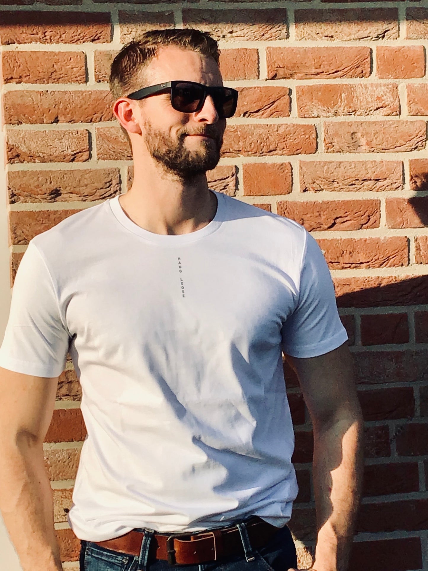 Unisex T-Shirt in Weiß mit dem Print "HANG LOOSE". Einfach ganz entspannt durch den Alltag. Das Leben genießen mit lässiger Streetwear von next summer.